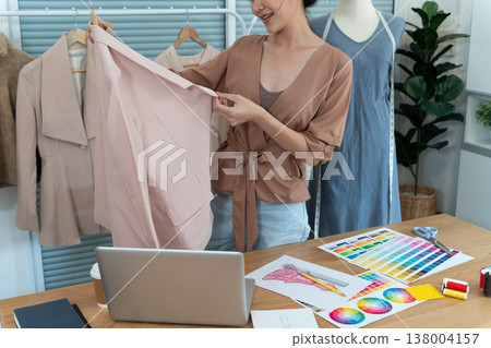 young designer woman standing and organizing her design shirt to develop 138004157