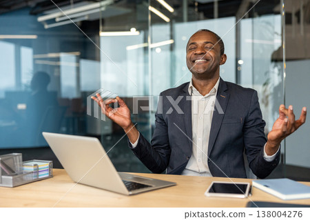 Confident man finding inner peace and mindful balance at his office workstation, practicing meditation to improve well-being and reduce workplace stress in a modern corporate environment Confident man finding inner peace and mindful balance at his office workstation, practicing meditation to improve well-being and reduce workplace stress in a modern corporate environment 138004276