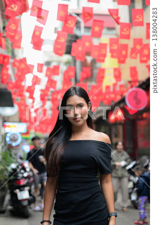 Young Thai Woman on Hanoi Old Quarter Street with Vietnamese Flags 138004283