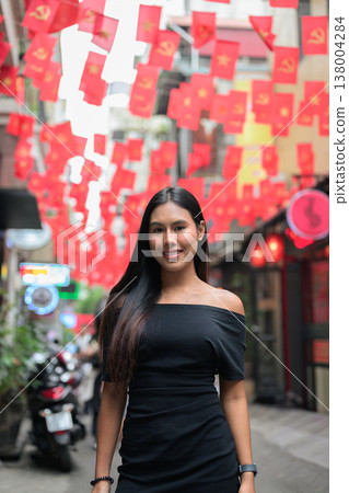 Young Thai Woman on Hanoi Old Quarter Street with Vietnamese Flags 138004284