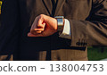 Businessman looks at the smartwatch on his hand. Businessman is checking time on the smartwatch. Close up. Modern gadgets and people concept. Modern communication. 138004753