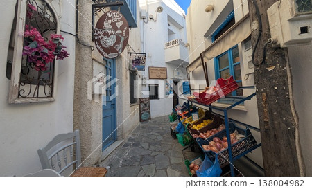 A narrow shopping street lined with signboards and vegetables 138004982