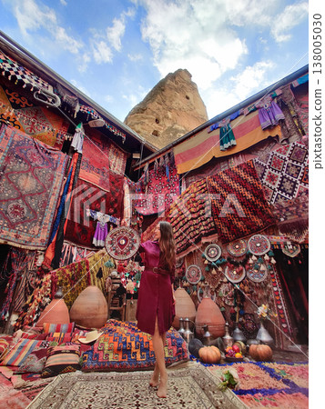 a beautiful girl in dress in a traditional turkish interior with many carpets on the wall a beautiful girl in dress in a traditional turkish interior with many carpets on the wall 138005030