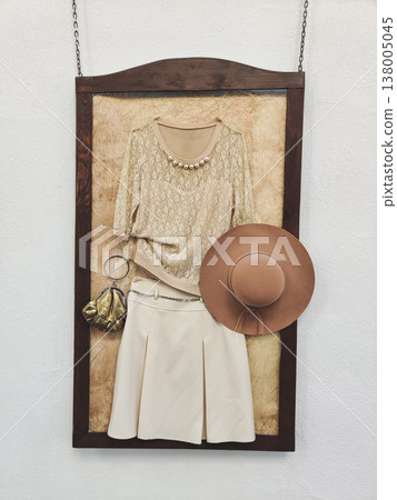 Vintage-style women's outfit displayed in a wooden frame Vintage-style women's outfit displayed in a wooden frame 138005045
