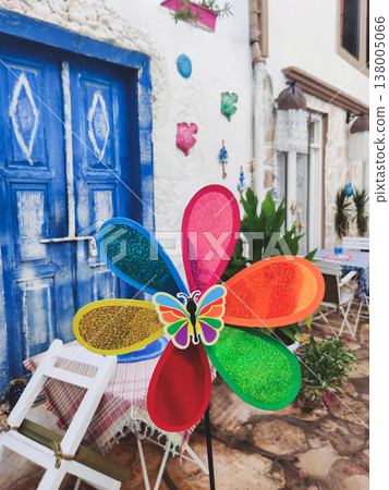 Colorful flower windmill toy in front of a blue door in Kalkan Turkey Colorful flower windmill toy in front of a blue door in Kalkan Turkey 138005066