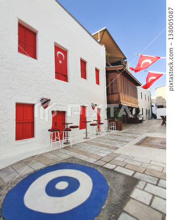 Street scene in Bodrum with a white building, Turkish flags, and an evil eye mosaic Street scene in Bodrum with a white building, Turkish flags, and an evil eye mosaic 138005087