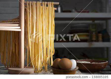 Homemade noodles hanging on wooden noodle dryer rack. Home cooking concept Homemade noodles hanging on wooden noodle dryer rack. Home cooking concept 138005105