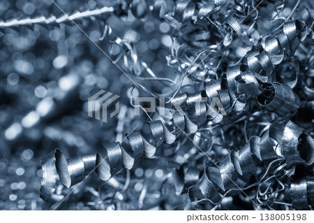 Close-up of a pile of blue-toned metal spiral chips and swarf from a high-precision CNC turning process. 138005198