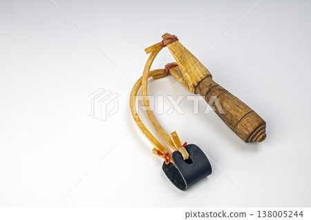 Antique Rustic Handmade Wooden Slingshot with Stretched Yellow Latex Rubber Bands and Black Leather Ammunition Pouch Isolated on Clean White Studio Background 138005244