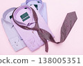 Three multicolored men's shirts and a tie on a pink background, a concept on the topic of matching a tie to a shirt, a top view 138005351