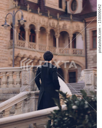 A man with his hands in his pockets climbs the castle stairs. A man with his hands in his pockets climbs the castle stairs. 138006042