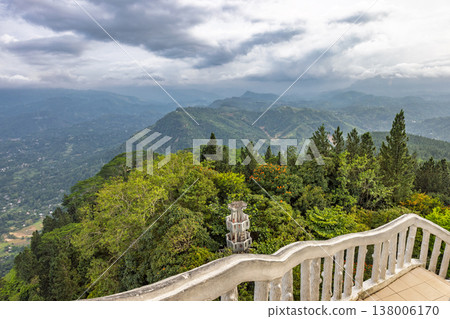 View from Ambuluwawa Tower, multi-religious temple complex located in Gampola, in Sri Lanka. Dramatic mountain landscape with lush forest from a high viewpoint and cloudy sky View from Ambuluwawa Tower, multi-religious temple complex located in Gampola, in Sri Lanka. Dramatic mountain landscape with lush forest from a high viewpoint and cloudy sky 138006170