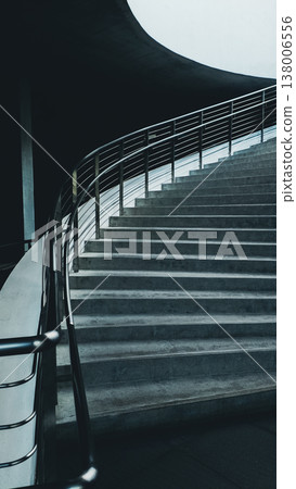 Modern curved staircase with metal railing in minimalist interior architecture, Contemporary concrete stairs with smooth lines and clean design in modern building 4k Modern curved staircase with metal railing in minimalist interior architecture, Contemporary concrete stairs with smooth lines and clean design in modern building 4k 138006556