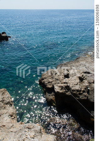 Crystal-clear blue sea and rocky shores under bright sunshine on the French island of Corsica in the Mediterranean Sea. Crystal-clear blue sea and rocky shores under bright sunshine on the French island of Corsica in the Mediterranean Sea. 138006898