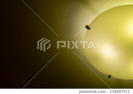 Close-up of the lamp in the house in warm tone with dark background. Lighting equipment. Close-up of the lamp in the house in warm tone with dark background. Lighting equipment. 138007011