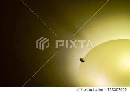 Close-up of the lamp in the house in warm tone with dark background. Lighting equipment. Close-up of the lamp in the house in warm tone with dark background. Lighting equipment. 138007012