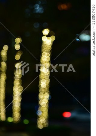 Abstract bokeh effect of the gold, yellow lights on black background. City street light decorations. Rows of LED gold colored light spots with black background. Abstract bokeh effect of the gold, yellow lights on black background. City street light decorations. Rows of LED gold colored light spots with black background. 138007416