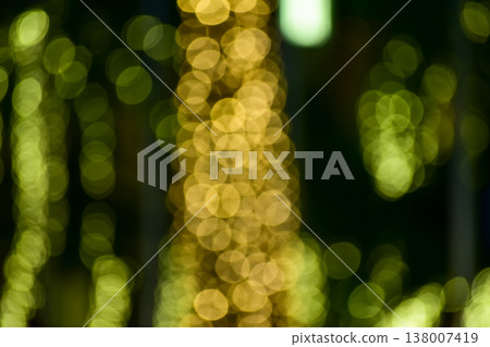 Abstract bokeh effect of the gold, yellow lights on black background. City street light decorations. Rows of LED gold colored light spots with black background. Abstract bokeh effect of the gold, yellow lights on black background. City street light decorations. Rows of LED gold colored light spots with black background. 138007419