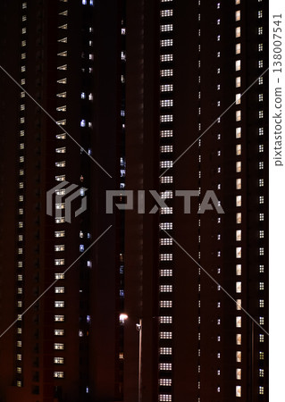 Close-up of the street light at night with buildings in the background. Cityscape and street scene at night with dark background. Close-up of the street light at night with buildings in the background. Cityscape and street scene at night with dark background. 138007541