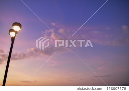 Close-up of the streetlight at the sunset, City light in the street with sky background. Cityscape and downtown scene. Close-up of the streetlight at the sunset, City light in the street with sky background. Cityscape and downtown scene. 138007576