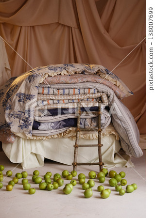 Stacked mattresses with ladder and green apples, princess and the pea concept Stacked mattresses with ladder and green apples, princess and the pea concept 138007699