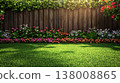 A weathered fence adorned with lush greenery and colorful flowers borders a vibrant lawn 138008865