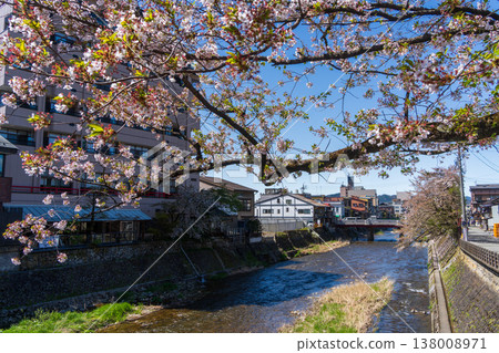 Cherry blossoms blooming along the river and a wooden bridge in Takayama City, Gifu Prefecture. Cherry blossoms blooming along the river and a wooden bridge in Takayama City, Gifu Prefecture. 138008971