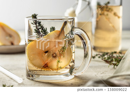 Pear thyme spritzer cocktail in glass cup. Festive homemade drink recipe for party Pear thyme spritzer cocktail in glass cup. Festive homemade drink recipe for party 138009022
