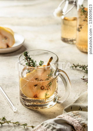 Pear thyme spritzer cocktail in glass cup. Festive homemade drink recipe for party 138009023