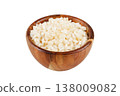 Raw dried white corn, used in the preparation of canjica, a Brazilian dessert made with corn, in a wooden bowl, isolated on a white background. 138009082