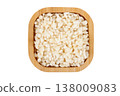 Raw dried white corn, used in the preparation of canjica, a Brazilian dessert made with corn, in a wooden bowl, isolated on a white background. 138009083