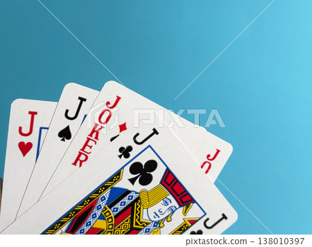 Playing cards with jacks and jokers displayed on a blue background during a game night with friends Playing cards with jacks and jokers displayed on a blue background during a game night with friends 138010397