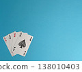 Four aces on a blue background with clear focus on the playing cards that show four Aces in a hand 138010403