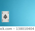 Playing cards are laid on a blue background showing the Ace of Spades with four black spade symbols 138010404