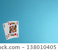 Playing cards on a blue surface with an ace of spades and three kings of hearts displayed together in a game setting 138010405