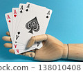 Holding four aces in a card game with a wooden hand on a blue background during daylight 138010408