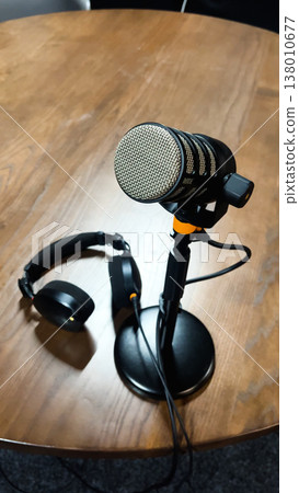 Professional microphone with headphones stands on a desk stand Professional microphone with headphones stands on a desk stand 138010677