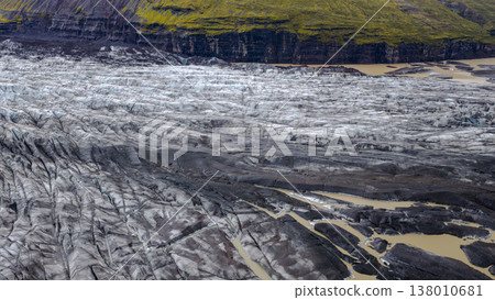 Aerial View of Glacier with Volcanic Ash and Mossy Cliff in Iceland 138010681