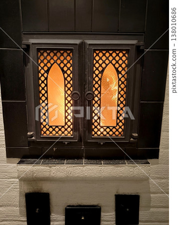 Decorative cast iron stove door with a burning fire inside Decorative cast iron stove door with a burning fire inside 138010686