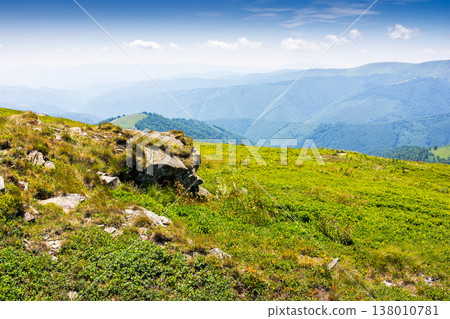 rock on the edge of the mountain meadow in summer. green alpine scenery with boulder on a sunny day. scenic view of carpathian mountains under blue sky. rolling landscape with hills and meadows rock on the edge of the mountain meadow in summer. green alpine scenery with boulder on a sunny day. scenic view of carpathian mountains under blue sky. rolling landscape with hills and meadows 138010781