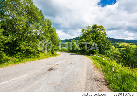 empty asphalt road through forest. old highway in carpathian mountain landscape on a cloudy sky. uzhanian pass in summer for travel by car background. countryside scenery empty asphalt road through forest. old highway in carpathian mountain landscape on a cloudy sky. uzhanian pass in summer for travel by car background. countryside scenery 138010796