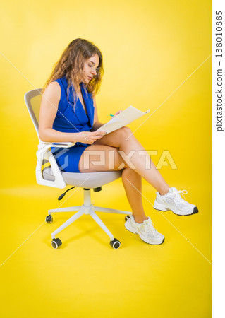 Woman working on document, sitting on modern office chair Woman working on document, sitting on modern office chair 138010885