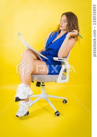 Woman contemplating new ideas sitting casually on chair Woman contemplating new ideas sitting casually on chair 138010893