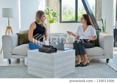 Young woman in psychological therapy session talking with professional mental health therapist 138011006