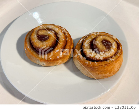 Sweet pastry rolls with sugar topping on white plate isolated composition. Dessert indulgence, bakery tradition, comfort food, simple pleasure, homemade style, minimal presentation 138011106