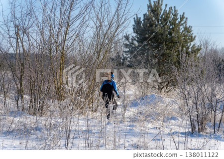 woman hiker walking through frosty snow covered landscape 138011122
