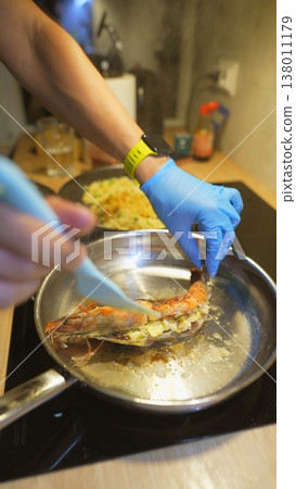 Closerange image showing hands basting seafood with butter and oil in pan 138011179