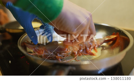 Skilled hands expertly cook prawns under intense kitchen environment Skilled hands expertly cook prawns under intense kitchen environment 138011180