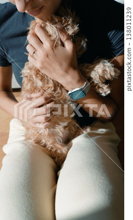 Casual image of person gently holding puppy during leisure moment Casual image of person gently holding puppy during leisure moment 138011239