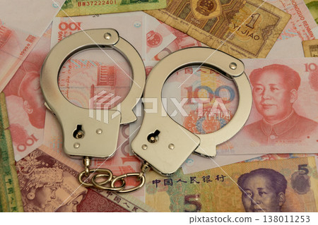 Metal handcuffs on yuan reflect corruption and economic violations 138011253